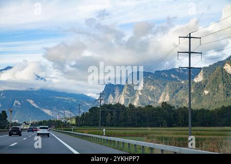 Une route sinueuse le long de lignes électriques, à travers les montagnes alpines menant de l'Italie à l'Allemagne en passant par la Suisse Banque D'Images
