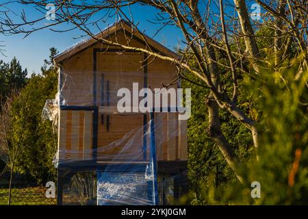 Une maison en bois dans les arbres pour les enfants protégé contre la neige et la pluie d'hiver avec du papier d'aluminium Banque D'Images