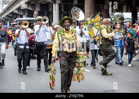 Membres du Sudan social and Pleasure Club dans la parade de deuxième ligne se déplaçant dans les rues du quartier Treme à la Nouvelle-Orléans, en Louisiane Banque D'Images