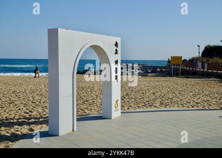 Ville de Sokcho, Corée du Sud - 3 novembre 2024 : L'arche blanche marque l'entrée de la plage d'Oeongchi, une plage sereine de sable et de surf le long de l'EAS Banque D'Images