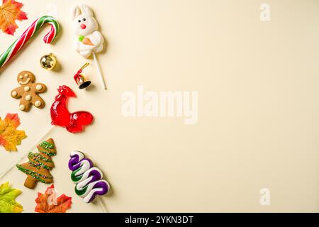 Fond de Noël avec bonbons au coq, biscuit en pain d'épices et diverses décorations de Noël sur fond jaune Banque D'Images
