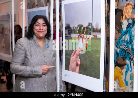 UTILISATION ÉDITORIALE SEULEMENT la réalisatrice Gurinder Chadha aux côtés d'une photographie de son film de 2002, Bend It Like Beckham à la National Portrait Gallery de Londres, qui célèbre 30 moments emblématiques des trois dernières décennies rendus possibles par le financement de la loterie nationale, pour marquer le 30e anniversaire de la loterie nationale. Date d'émission : mardi 19 novembre 2024. Banque D'Images