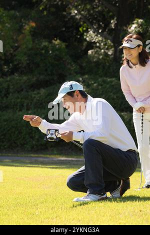 Couple d'âge moyen jouant au golf Banque D'Images