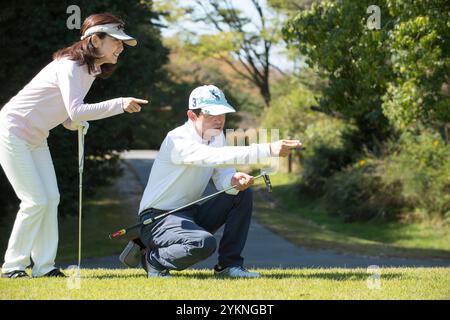 Couple d'âge moyen jouant au golf Banque D'Images