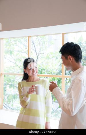 Couple buvant du thé par le rebord de la fenêtre Banque D'Images