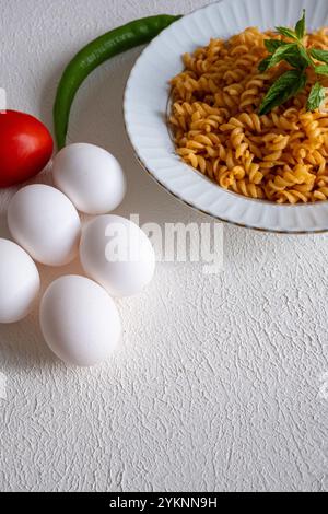 pâtes spirales avec sauce tomate crémeuse sur une assiette blanche au ralenti Banque D'Images