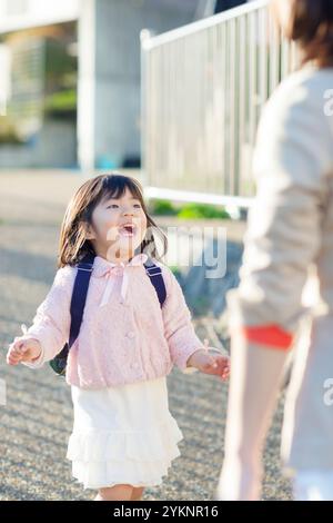 Fille de maternelle courant vers mère Banque D'Images