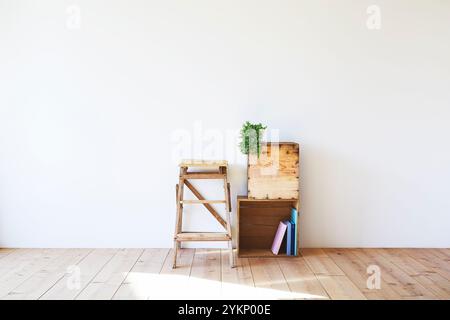 Plancher en bois, mur blanc, boîte à vin et escabeau Banque D'Images