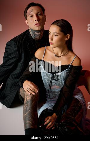 Un couple à la mode pose étroitement ensemble, mettant en valeur leurs styles et tatouages uniques. Banque D'Images