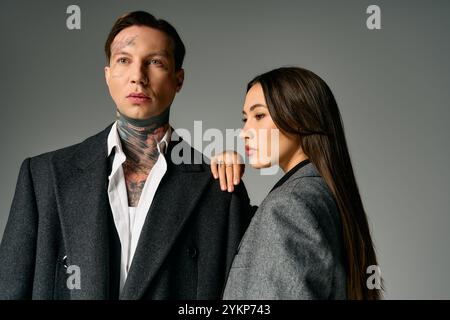 Un jeune couple attrayant met en valeur leurs styles tendance dans un cadre intérieur élégant. Banque D'Images