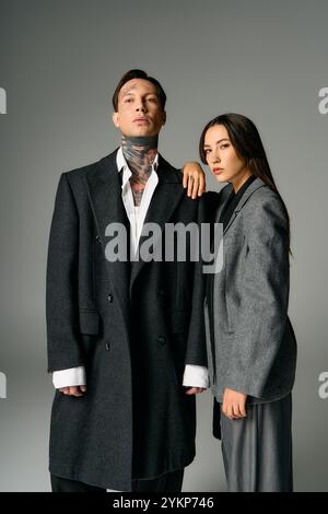 Un jeune couple attrayant présente leurs looks à la mode dans un environnement de studio élégant. Banque D'Images