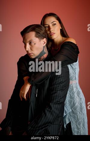 Un jeune couple captivant embrasse tendrement dans un studio élégant, rayonnant de confiance. Banque D'Images