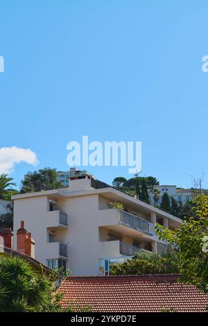 Immeuble moderne à Marseille avec un ciel bleu clair et la végétation environnante. Le bâtiment dispose de balcons et d'un design contemporain, ma Banque D'Images