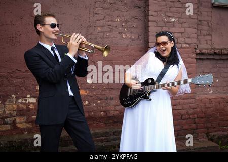 La mariée et le marié jouent des instruments de musique Banque D'Images