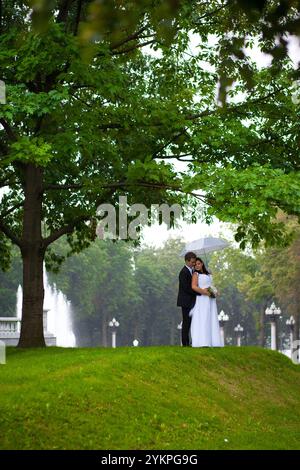 Un couple romantique s'embrassant sous un arbre ensemble Banque D'Images