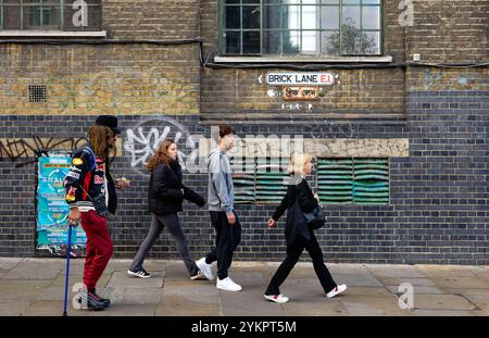 Les gens marchent près du panneau de rue Brick Lane, Whitechapel, Londres Banque D'Images