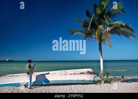 Joueur de guitare marchant sur la plage dans le village de Progreso, près de Merida, Golfe du Mexique, Yucatan, Mexique Banque D'Images