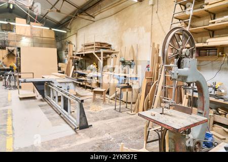 Une vue détaillée d'un atelier de sciage présentant divers outils et matériaux de travail du bois. La scène capture l'essence du travail d'équipe, de la formation et Banque D'Images