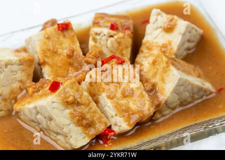 Tempeh ou tempe mariné dans une sauce aux cacahuètes et Chili. Banque D'Images