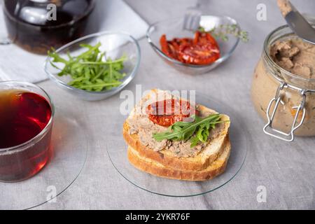 Pâté de foie de poulet avec pain de blé, roquette, tomates séchées et thé noir. Cuisine rustique traditionnelle maison. Option petit déjeuner ou en-cas. Sélectionnez Banque D'Images