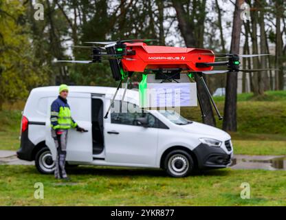 Welzow, Allemagne. 19 novembre 2024. Un drone Morpheus Logistik GmbH décolle avec un colis lors d’un événement de presse pour la livraison de journaux à l’aide de drones sur l’aérodrome de Welzow. Malgré une pluie battante, le projet pilote a commencé le même jour dans la région de Welzow, dans le sud du Brandebourg, pour livrer commercialement des journaux publicitaires à des clients privés en utilisant pour la première fois des drones volant automatiquement. Crédit : Patrick Pleul/dpa/Alamy Live News Banque D'Images