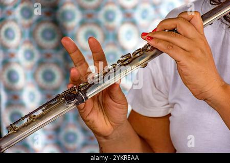 Détail des mains d'une femme jouant de la flûte transversale lors d'une performance musicale Banque D'Images