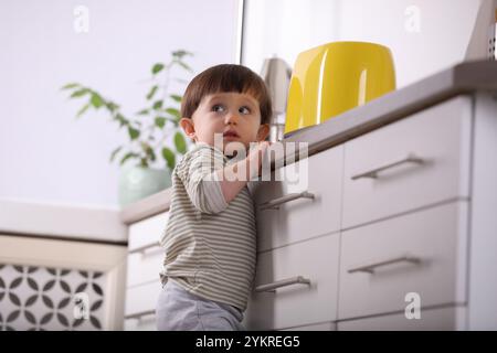 Petit garçon jouant avec grille-pain dans la cuisine, vue à angle bas. Situation dangereuse Banque D'Images