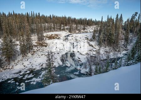 Aperçu hivernal de la rivière Cameron gelée et d'une chute d'eau dans le parc territorial de Hidden Lake, Territoires du Nord-Ouest, Canada Banque D'Images