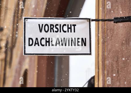 Augsbourg, Bavière, Allemagne - 18 novembre 2024 : avertir les avalanches de toit, dit un panneau sur un mur de maison. Symbole d'avertissement et de danger en cas de neige ou de chute de neige d'avalanches qui pourraient tomber du toit d'une maison et heurter les piétons. *** Vorsicht Dachlawinen, steht auf einem Schild an einer Hauswand. Symbol für Warnung und Gefahr BEI Schnee, bzw. Schneefall von Lawinen die vom Haus-Dach Fallen und Fußgänger treffen könnten. Banque D'Images