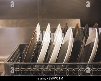 Les assiettes sont soigneusement disposées dans un panier de lave-vaisselle Banque D'Images