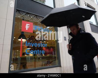 Les piétons munis de parapluies passent devant le centre Fidelity Investor détenu par la société de services financiers Fidelity International Ltd, ou fil pour faire court, dans le centre de Londres, au Royaume-Uni Banque D'Images