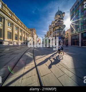 Séville, Espagne, janvier 28 2021, Un cycliste passe devant le pittoresque bâtiment Adriatica sur l'Avenida de la Constitucion à Séville. La rue est bordée d'esprit Banque D'Images