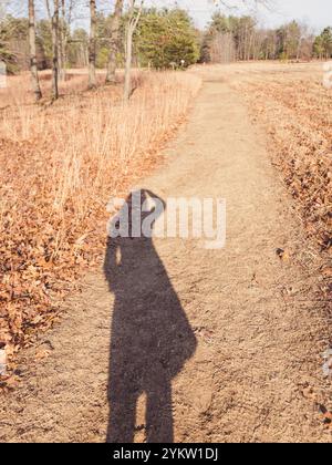 Ombre longue de photographe Autoportrait personne sur Dirt Path Banque D'Images