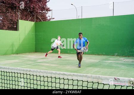 Deux jeunes amis jouant au paddle-tennis sur un court. Concept sportif. Copier l'espace Banque D'Images