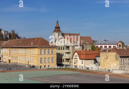 Une photo de l'église noire et du lycée sportif voisin de Brasov Banque D'Images