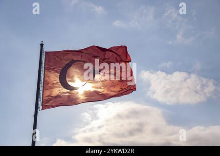 Une photo du drapeau turc contre un ciel bleu nuageux Banque D'Images