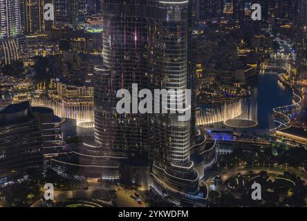 Une photo du Dubai Fountain Show, la nuit, et le fond de la Burj Khalifa, à côté d'autres bâtiments du centre-ville de Dubaï Banque D'Images