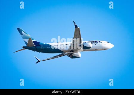 Calgary Alberta Canada, octobre 30 2024 : L'avion de WestJet Airlines quitte l'aéroport de Calgary YYC avec un fond de ciel bleu Banque D'Images