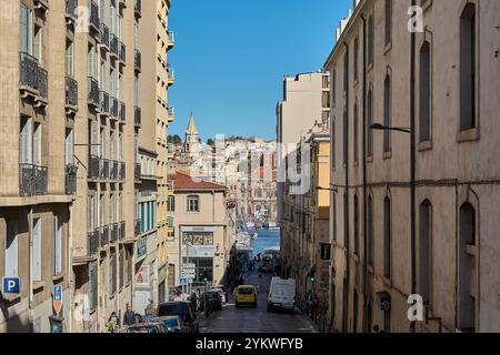 Marseille. France - 19 novembre 2024 : vue panoramique sur une rue marseillaise descendant vers le port, avec une architecture historique et une ville animée Banque D'Images