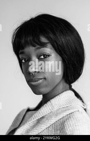 Jeune femme afro-américaine noire avec les cheveux droits regardant la caméra - Portrait vertical - montage noir et blanc Banque D'Images