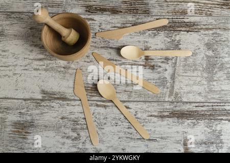 Mortier en bois avec poussoir et autres outils. Couteaux et cuillères. Vue de dessus à plat Banque D'Images