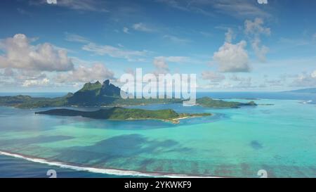 Beauté à couper le souffle île volcanique de Bora Bora, Polynésie française, bungalows de luxe sur l'eau et atoll de barrière de récifs coralliens dynamique. Paradis de la nature sauvage à distance voyage de luxe exotique d'été. Vol de drone Banque D'Images