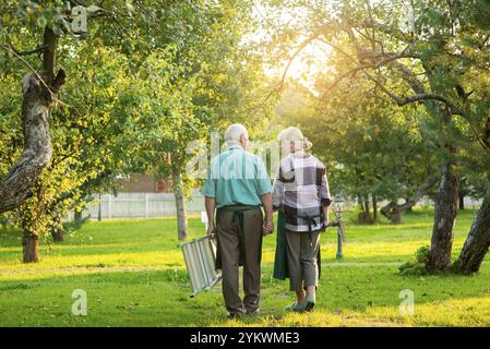 Couple senior tenant la main à l'extérieur. Femme et homme, vue arrière. Ensemble sous le soleil Banque D'Images