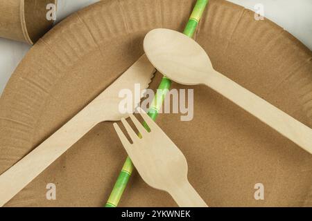 Vue de dessus gros plan ustensiles en bois et paille verte. Assiette avec fleur et cuillère Banque D'Images
