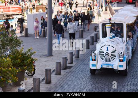 Marseille. France - 19 novembre 2024 : un train touristique blanc et bleu transportant des passagers dans les rues pavées de Marseille, France. Le tr Banque D'Images