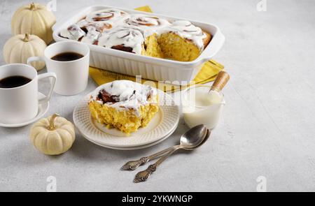 Parfumés rouleaux de cannelle fraîchement cuits ou cinabons recouverts de glaçage à la crème blanche sur les assiettes sur fond blanc. Recette Cinnabons. Hom traditionnel Banque D'Images