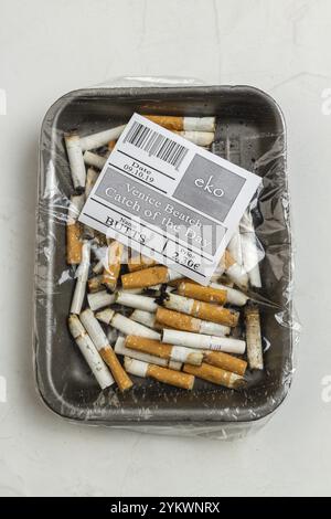 Pile de cigarettes usagées enveloppée de plastique vue de dessus. Fond blanc de prise de vue verticale Banque D'Images