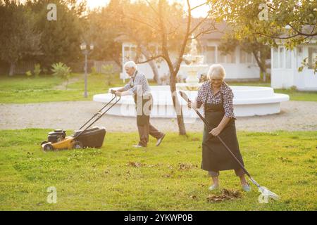 Couple de vieux jardiniers travaillant. Les gens dans le jardin ensoleillé. Achetez des outils et du matériel de jardinage Banque D'Images