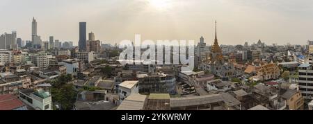 Une photo panoramique des toits des quartiers Samphanthawong, Bang Rak et Khlong San de Bangkok, avec le temple Wat Traimit Withayaram Worawihan Banque D'Images