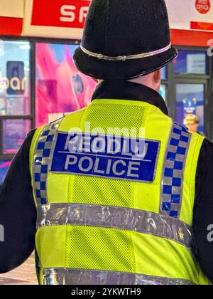 Cardiff, pays de Galles, Royaume-Uni - 17 novembre 2024 : vue arrière d'un officier de la police du sud du pays de Galles en service dans le centre-ville la nuit Banque D'Images